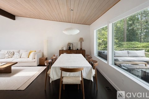 A modern dining room with a wooden table and chairs.