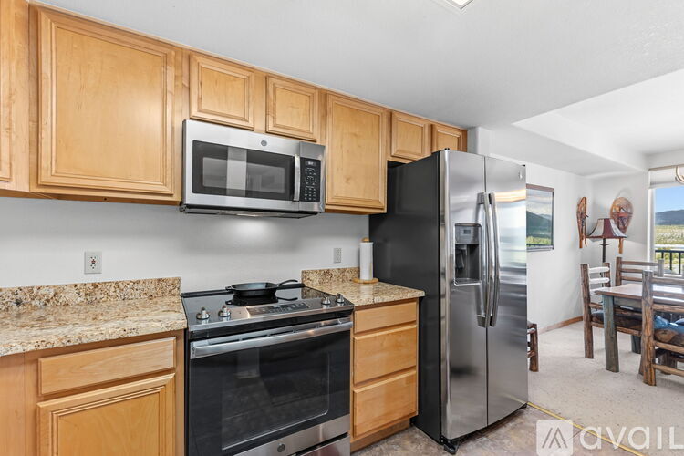 A kitchen with wooden cabinets and a black refrigerator.