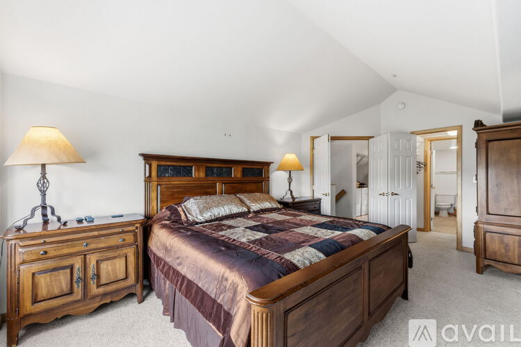 A bedroom with a large bed and wooden furniture.