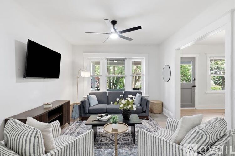 A living room with a striped couch and a flat screen TV.