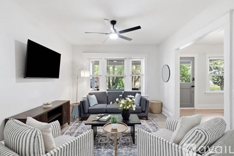 A living room with a striped couch and a flat screen TV.