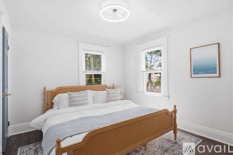 A bedroom with a large bed and a picture on the wall.