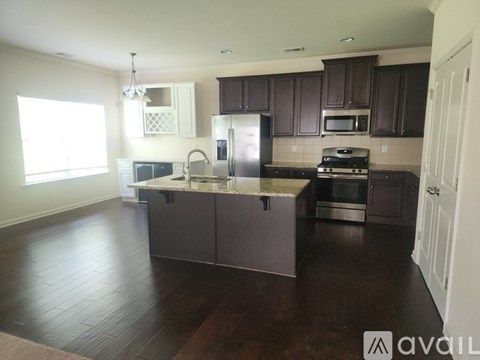 A kitchen with dark wood cabinets and a white island.