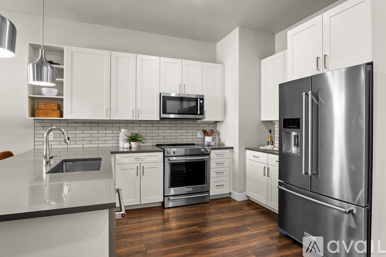 A modern kitchen with white cabinets and stainless steel appliances.