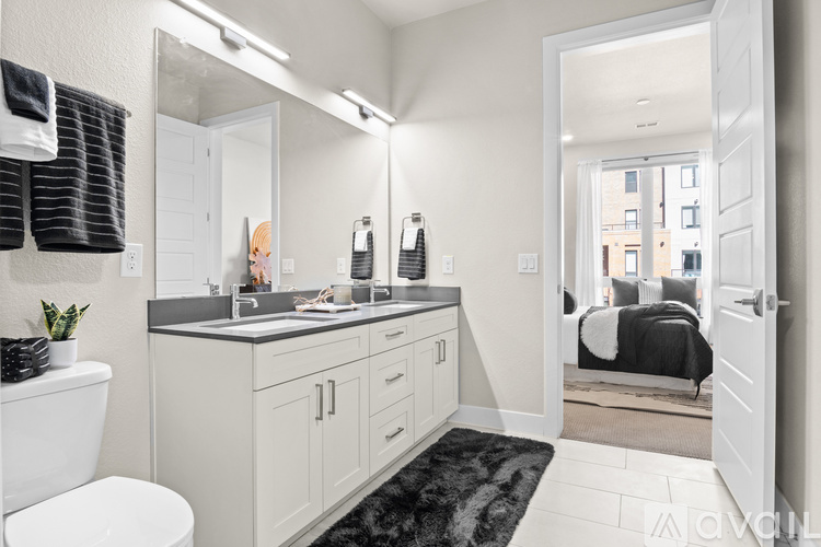 A bathroom with a white toilet, sink, and mirror.
