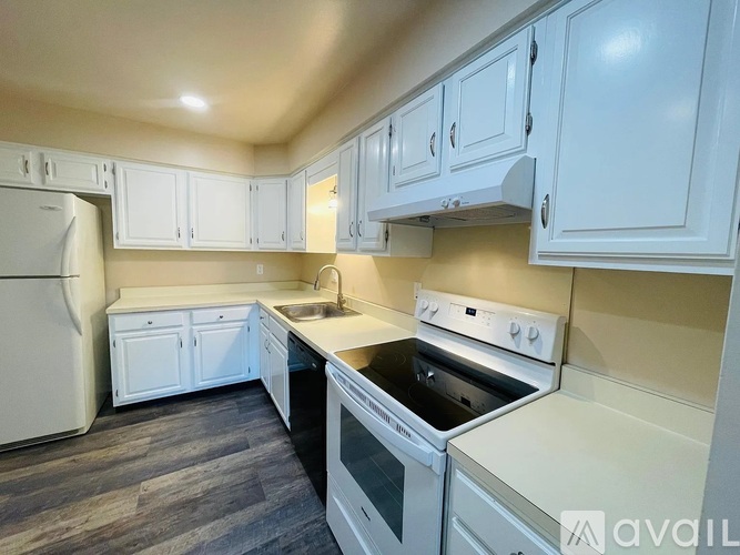 A kitchen with white appliances and cabinets.