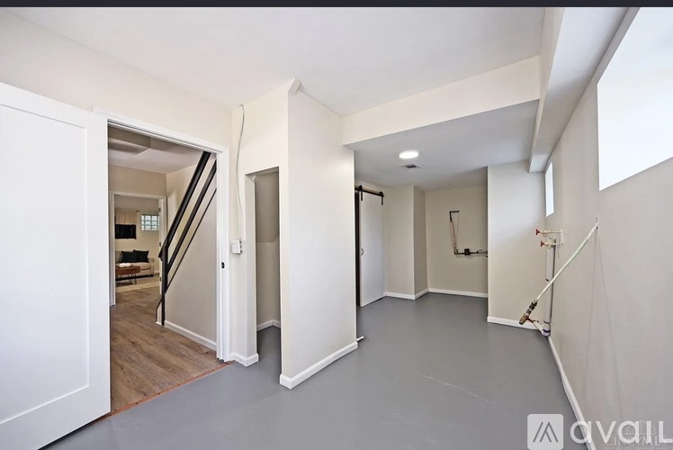 A spacious, empty room with a staircase leading to another floor.