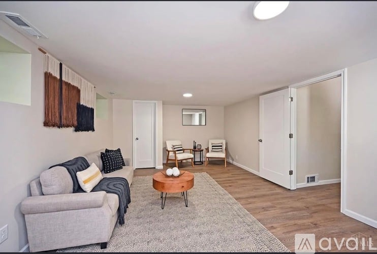 A living room with a grey couch and a wooden coffee table.