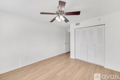 A room with a ceiling fan and a white wardrobe.