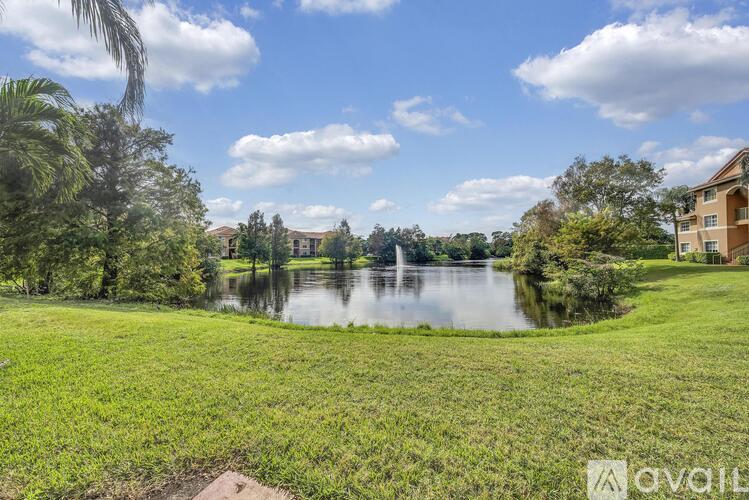 A serene landscape with a pond and a building in the distance.