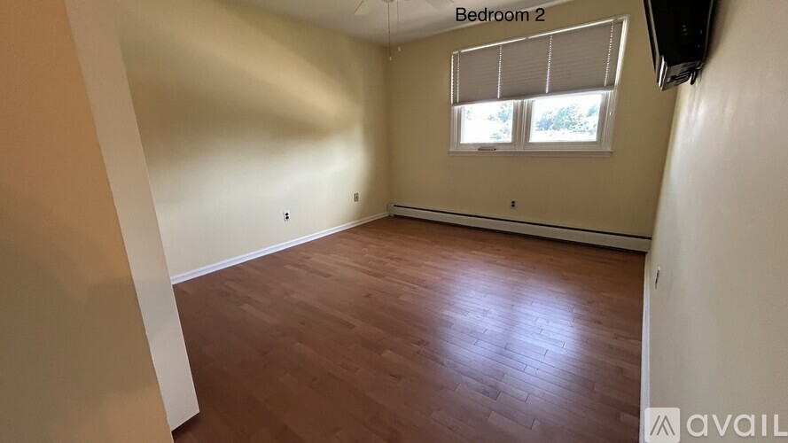 Bedroom 2 has a window with blinds and wooden flooring.