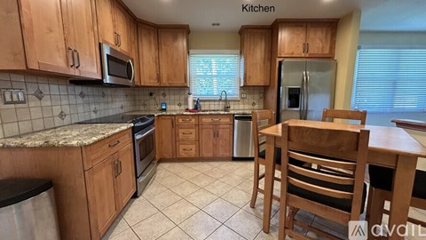 A kitchen with wooden cabinets and a granite countertop.