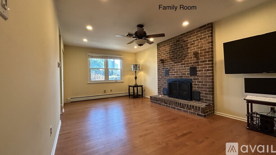A spacious family room with a fireplace and a television.