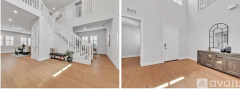 A spacious living room with a staircase and a side table with a mirror.