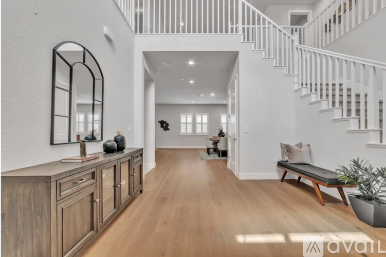 A spacious living room with a staircase leading to the upper floor.