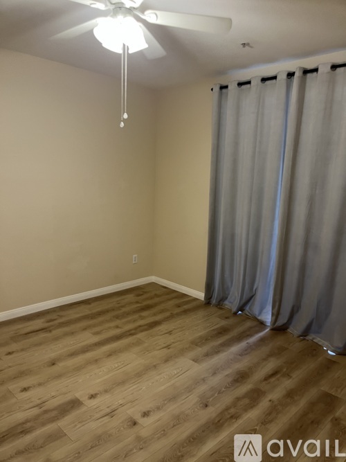 A room with wooden flooring and a ceiling fan.