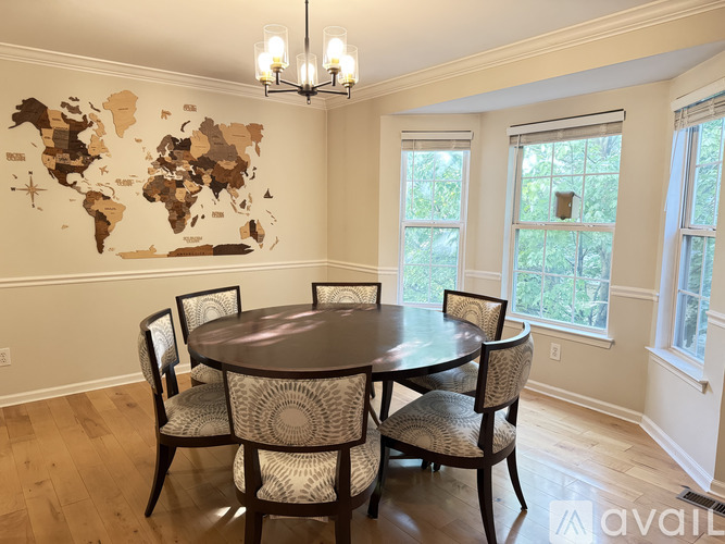 A dining room with a world map on the wall and a table with chairs.