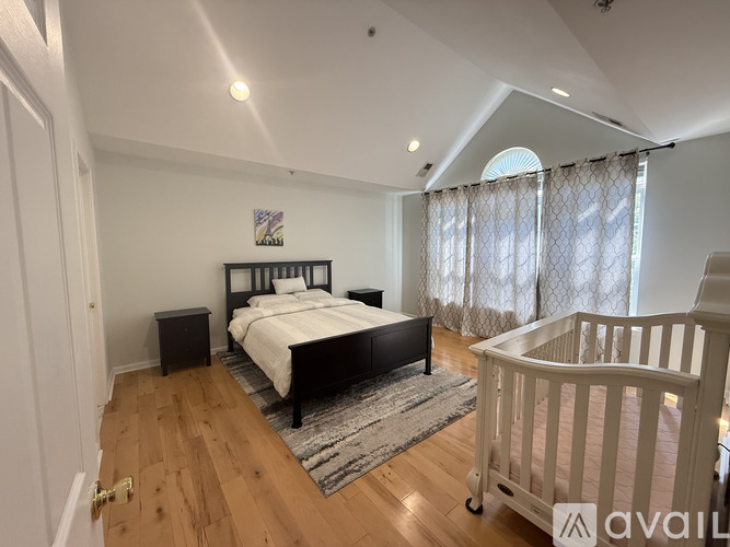 A bedroom with a large bed and a crib.
