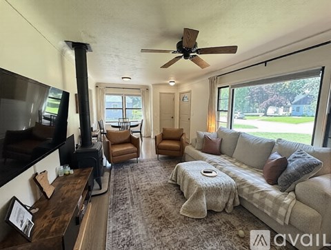 A living room with a grey couch and a fireplace.