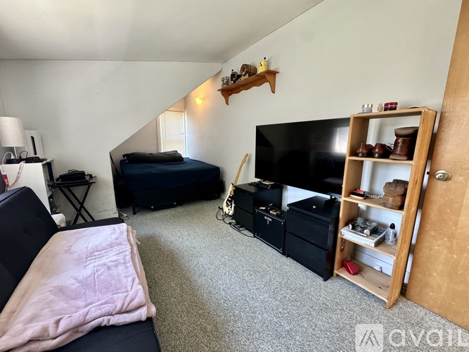A living room with a black couch and a television.