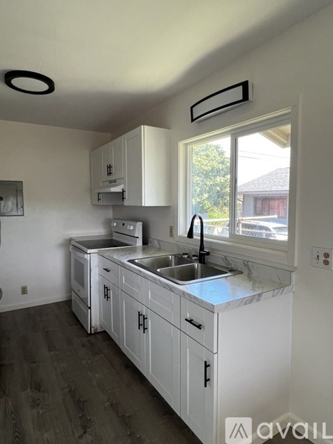 A kitchen with white cabinets and a sink.