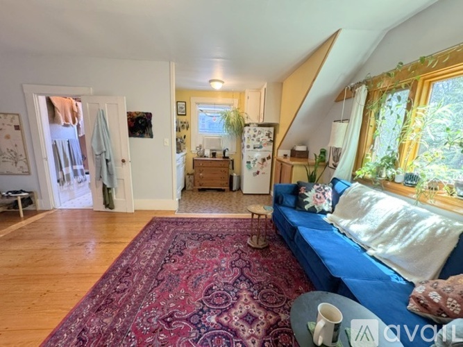 A living room with a blue couch and a rug.