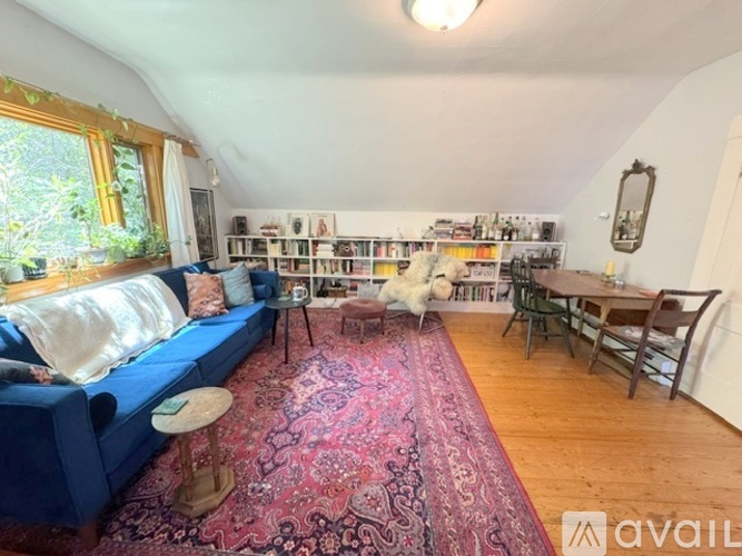 A living room with a blue couch and a rug.