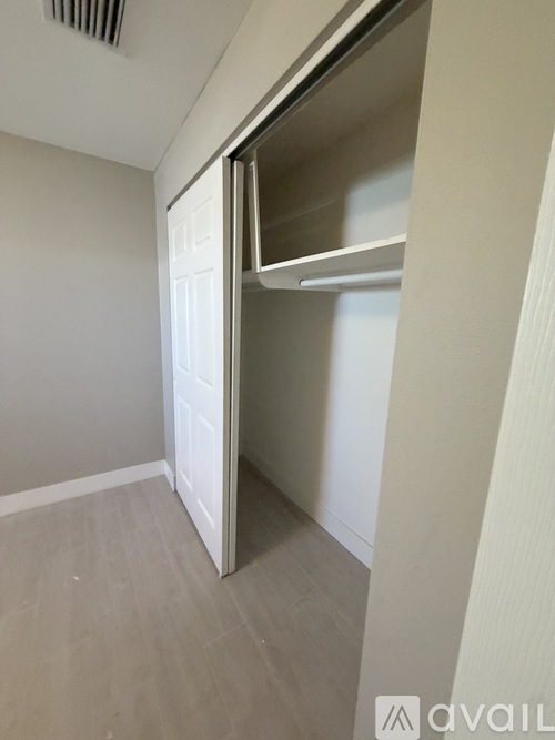 A small, empty room with a white door and a white wall.