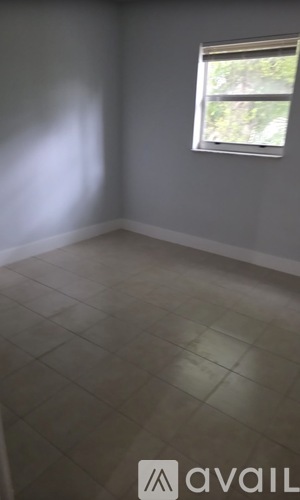 A room with a window and tiled floor.