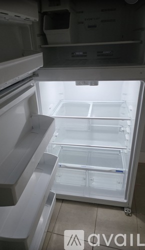 A white refrigerator with the door open and shelves inside.