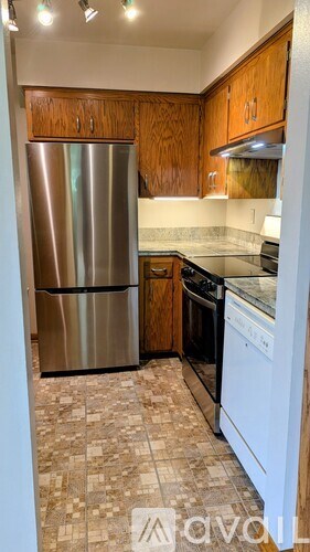 A kitchen with a stainless steel refrigerator and a white dishwasher.