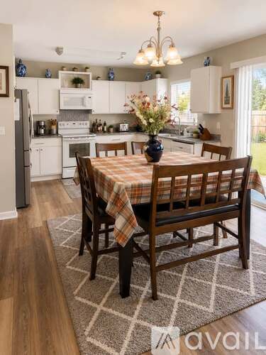 A kitchen with a table set for four with a checkered tablecloth.