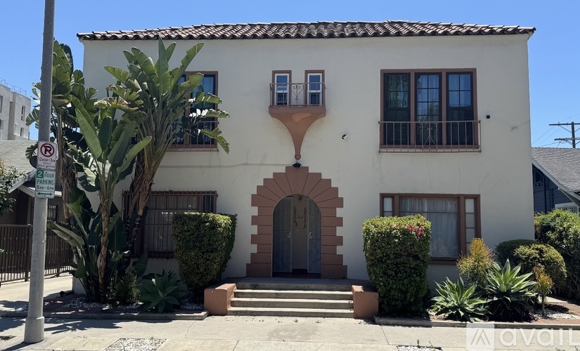A white house with a brown roof and a brown door.
