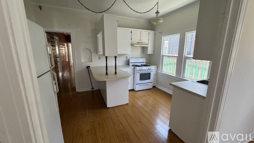 A kitchen with wooden floors and white walls.