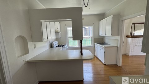 A kitchen with white cabinets and a large island.
