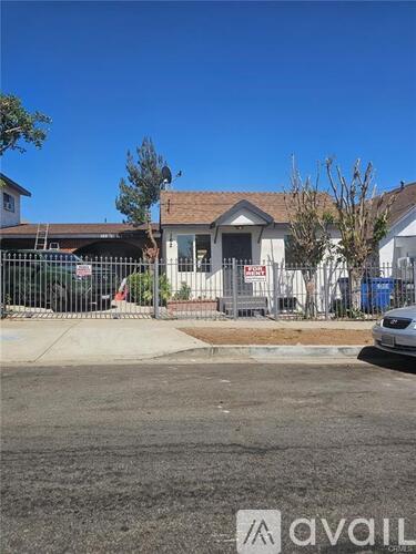 A house with a white fence and a car parked in front.