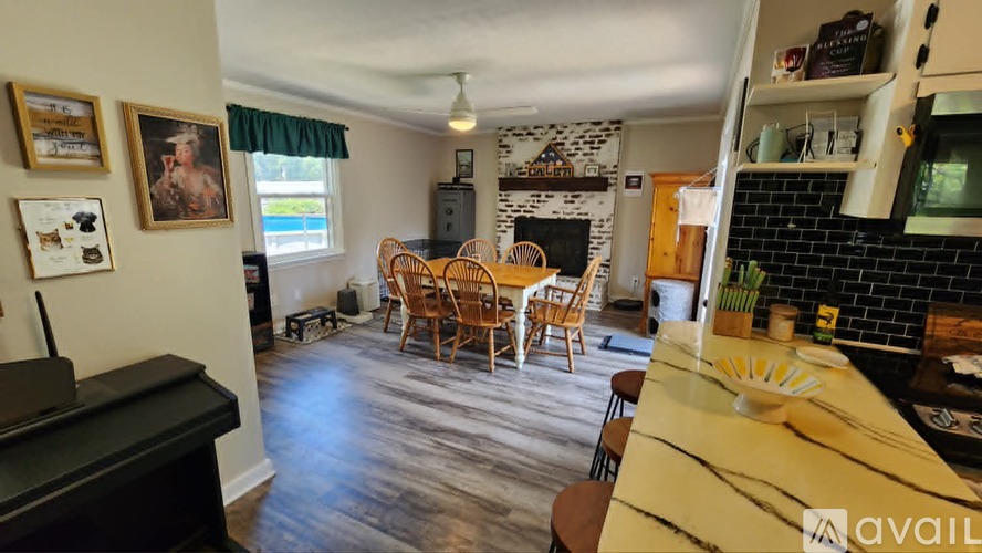 A living room with a piano and a dining table with chairs.