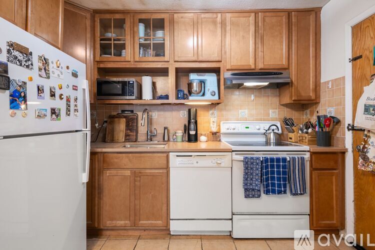 A kitchen with wooden cabinets and white appliances.