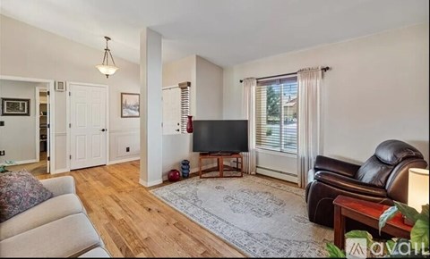 A living room with a flat screen TV and a brown leather couch.
