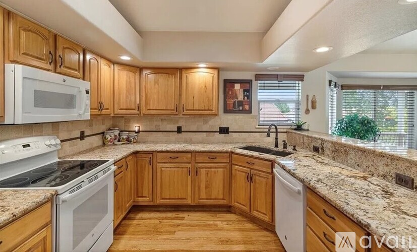 A kitchen with wooden cabinets and granite countertops.