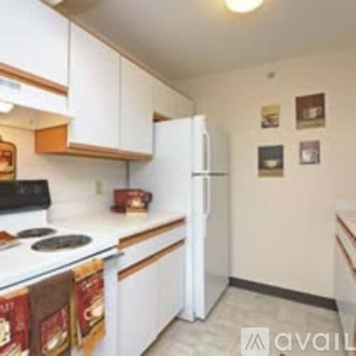 A kitchen with white cabinets and a white fridge.
