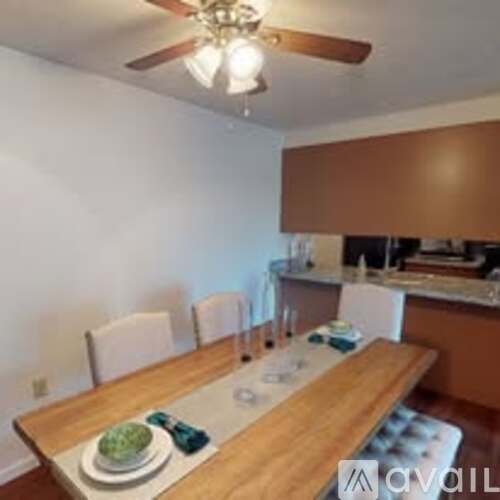 A dining room with a wooden table and chairs.