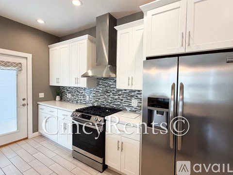 A kitchen with a stove top oven and a refrigerator.