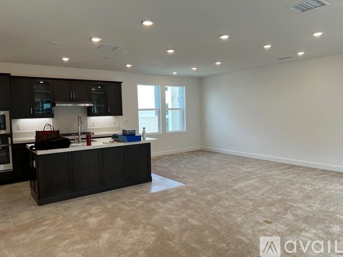A spacious kitchen with dark brown cabinets and a light-colored floor.