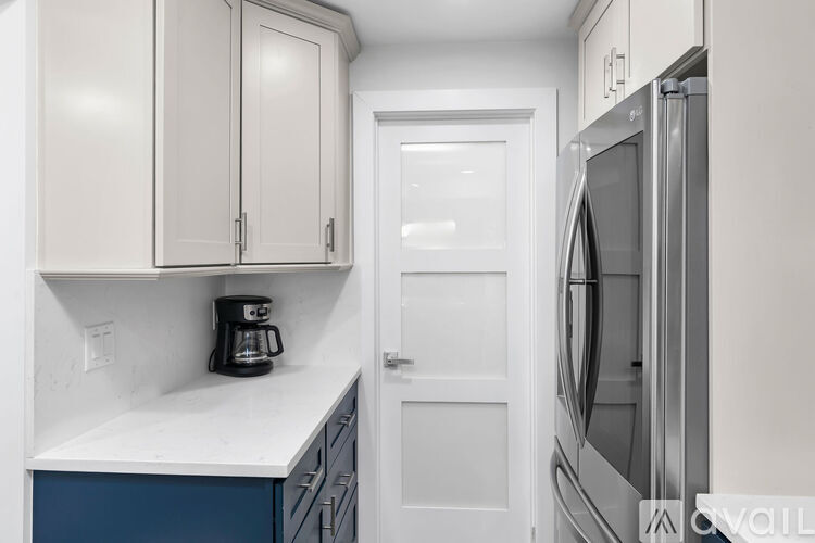 A kitchen with white cabinets and a blue drawer.