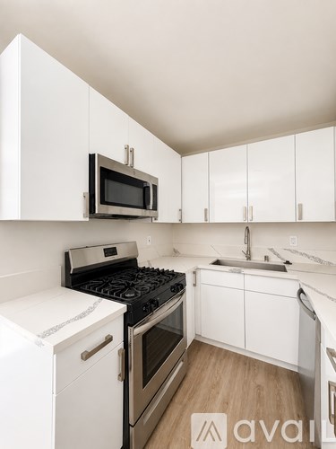 A kitchen with white cabinets and a black stove top oven.