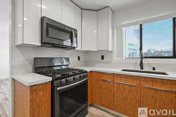 A kitchen with a black stove and a black microwave.