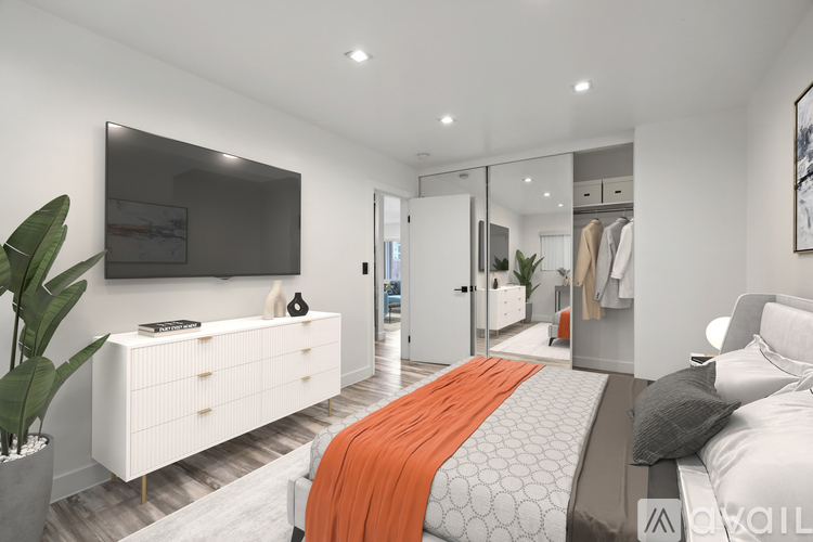 A modern bedroom with a large bed and a TV on the wall.