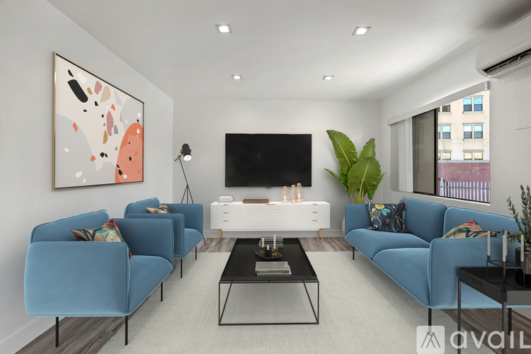A living room with blue couches and a television.