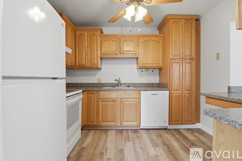 A kitchen with wooden cabinets and a white refrigerator.
